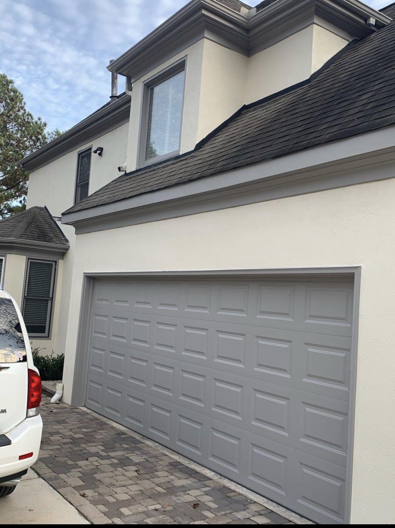 Freshly painted gray garage door on a stucco home